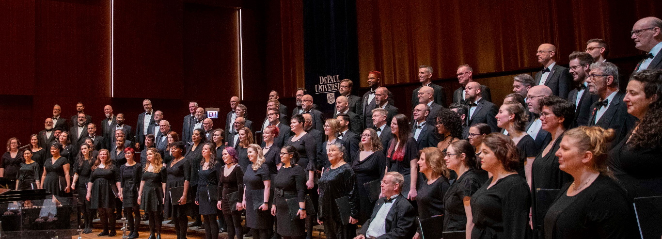 Windy City Treble Quire and Gay Chorus sing together on stage. They are wearing black dresses and black suits.